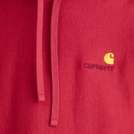 Red Carhartt Loose Fit Hoodie Hoodie unisex detail view 4 | Dash Racegear — Detailed image of the Carhartt logo sewn onto the hand-warmer pocket of the red midweight fleece hoodie.