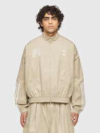 Adidas x Willy Chavarria Compton Cowboys Chino Track Jacket Jacket unisex detail view 3 | Dash Racegear — Adidas x Willy Chavarria x Compton Cowboys chino beige track jacket with ribbed collar and zip pockets for everyday cool looks.