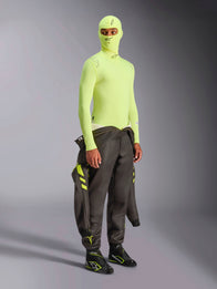Alpinestars ZX Evo V3 Long Sleeve Top, Yellow Fluo, motorsport base layer worn with matching balaclava and dark racing suit tied at the waist, high-visibility neon yellow fire-resistant underwear