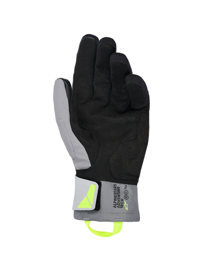 Alpinestars XT-3 Drystar® Insulated Gloves, Black and Dark Gray motorcycle gloves, palm view showing soft black suede and gray textile, fluorescent yellow pull tab and logo, 'ALPINESTARS ADVENTURE TECH' branding on the cuff, waterproof and insulated for adventure riding