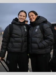 Chelsea FC UEFA Women’s Champions League Puffer Jacket Puffer Jacket unisex front product view | Dash Racegear — Chelsea FC 2025 black hooded puffer jacket for women features bold design and warmth, ideal for fan outings.