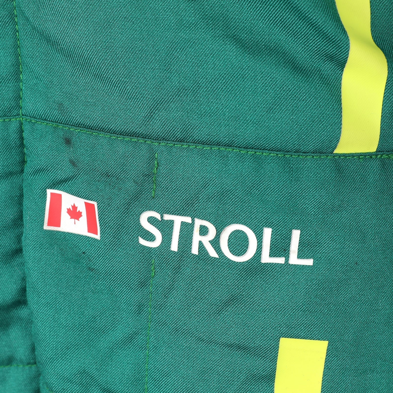 Lance Stroll wearing his green Aston Martin F1 race suit at the 2025 British Grand Prix – Dash Racegear.