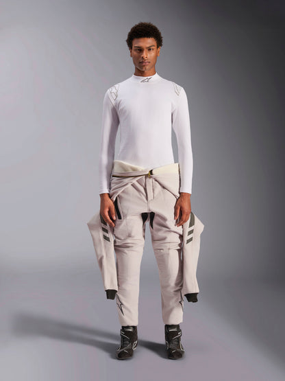 Alpinestars ZX Evo V3 Top, Long Sleeve, White, auto racing base layer worn with a light-colored racing suit tied around the waist and black racing boots, featuring a mock neck with logo and shoulder branding, professional flame-resistant motorsport underwear