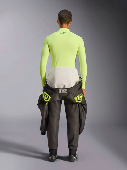 Alpinestars ZX Evo V3 Top, Long Sleeve Base Layer, Yellow Fluo, back view of a driver with a racing suit tied around the waist, vibrant neon yellow flame-resistant top featuring a small black logo on the neck and a slim athletic fit